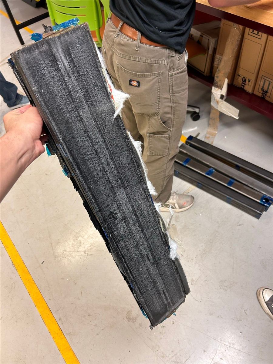 Carbon fiber beam section held up in the lab