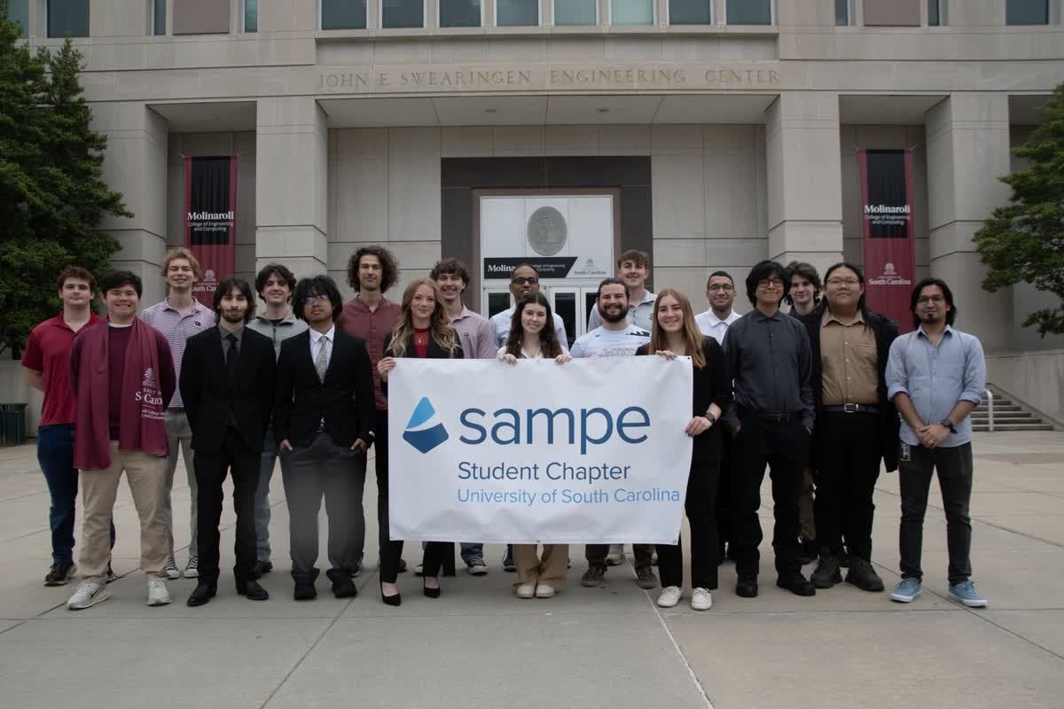 UofSC SAMPE student chapter with banner outside Swearingen Engineering Center